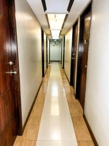 un pasillo en un edificio de oficinas con un pasillo largo en Stone House Manila en Manila