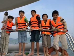 芽莊的住宿－海港景別墅，四个穿救生衣的孩子站在船上