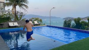 芽莊的住宿－海港景別墅，跳进游泳池的男人