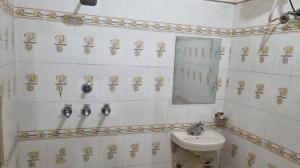 y baño con lavabo y espejo. en The Royal Elite Guest House, en Jalandhar