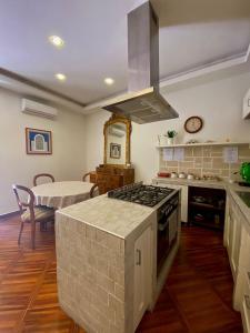Il comprend une cuisine équipée d'une cuisinière. four supérieur à côté d'un lit dans l'établissement Trinità degli Spagnoli house, à Naples