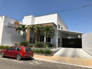 a red car parked in front of a building at Acqua Ville Flats II - Caldas Novas Center in Caldas Novas