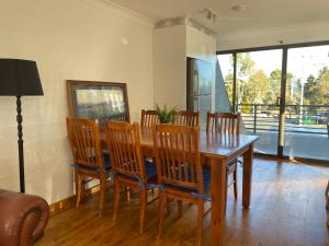 a dining room with a wooden table and chairs at Jindabyne Lake View in Jindabyne