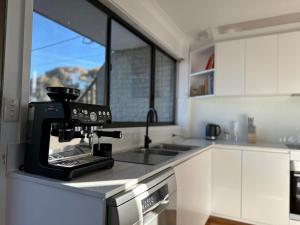 a kitchen with a black coffee machine on a counter at Jindabyne Lake View in Jindabyne