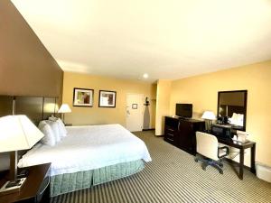 um quarto de hotel com uma cama grande e uma secretária em Whitney Inn & Suites em Hamden