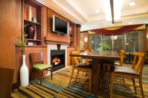 a dining room with a fireplace and a table and chairs at Fairfield Inn & Suites Burley in Burley