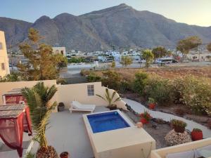 a villa with a swimming pool and mountains in the background at Marina's Studios in Perivolos