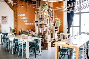 a dining room with tables and chairs and a tree at TinyParks Eiland Tiengemeten in Zuid-Beijerland +37 photos
