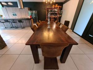un tavolo in legno in un ristorante con sedie intorno di MEGA APPARTEMENT a Le Tampon