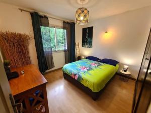 Schlafzimmer mit einem Bett, einem Tisch und einem Fenster in der Unterkunft MEGA APPARTEMENT in Le Tampon