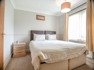 um quarto com uma cama grande e uma janela em Clover Cottage - W40835 em Horsford