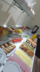ein Buffet mit vielen verschiedenen Speisen auf dem Tisch in der Unterkunft Hotel Paris in São Paulo