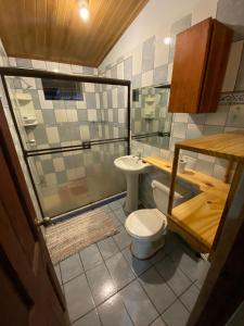 a small bathroom with a toilet and a shower at La Casa de Cachi in Paquera