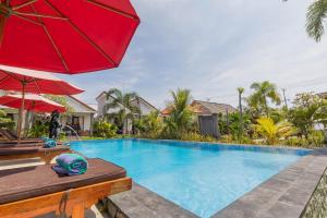 una piscina con una sombrilla roja junto a una casa en Favorit Exclusive Villa & Bungalow en Nusa Penida