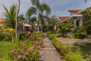 un sentiero che conduce a una casa con fiori rosa di Favorit Exclusive Villa & Bungalow a Nusa Penida