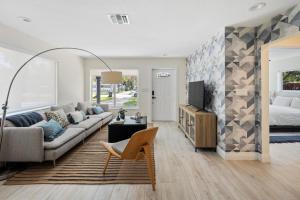 uma sala de estar com um sofá e uma cama em Tropical Bliss: 3BR House + Private Yard in Miami em Hollywood