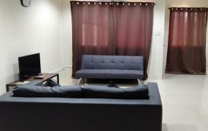 a living room with a couch and a tv at Astra Bella Apartment - Unit 2 in Dumaguete