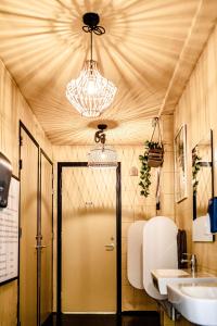 a bathroom with a door and a sink and a chandelier at TinyParks Cast Away in Zuid-Beijerland