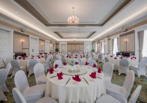 un salón de banquetes con mesas blancas y sillas blancas en FLC Luxury Resort Vinh Phuc en Hoằng Xá