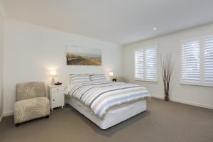1 dormitorio blanco con 1 cama y 1 silla en The Hamptons, en Cowes