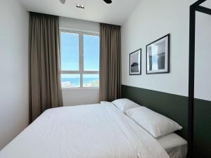 a bedroom with a white bed and a window at TUJU Homes (SeaView, Drawbridge & KTCC Mall) in Kuala Terengganu +105 photos