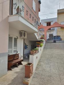 a building with a balcony and a bench on a street at Case Vacanza Armando "Lipari" in Canneto