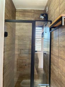 a shower with a glass door in a bathroom at Pousada Casa de Campos Mountain House in Campos do Jordão