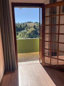 an open door to a room with a view at Pousada Casa de Campos Mountain House in Campos do Jordão