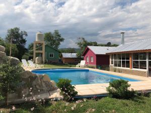 a swimming pool in front of a house with a barn at Nature, comfort, and authenticity in the Salta countryside in Vaqueros +21 photos