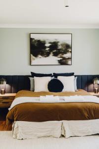 um quarto com uma cama grande e um cobertor castanho em Bendalong - Rural Retreat, Short Drive to CBD em Orange