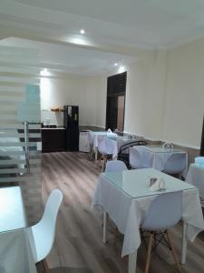 a dining room with white tables and white chairs at Hotel Paris in São Paulo