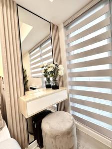 um quarto com um toucador e um espelho em Aurum Latte Suite at Azure North em Lagundi