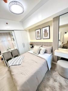 um quarto com uma grande cama branca num quarto em Aurum Latte Suite at Azure North em Lagundi
