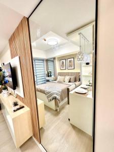 uma sala de estar com uma cama e um espelho em Aurum Latte Suite at Azure North em Lagundi