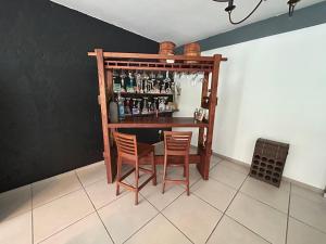 eine Bar mit zwei Stühlen und einem Tisch in einem Zimmer in der Unterkunft MEGA APPARTEMENT in Le Tampon