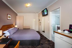una camera d'albergo con letto e bagno di Quality Hotel Bayswater a Perth
