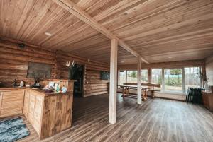 a large room with wooden walls and wooden floors at Laukupės sodyba in Rokiškis