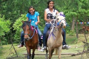 Due donne a cavallo in un parco di Nice One Palace a Srinagar