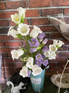 un vase bleu rempli de fleurs blanches et violettes dans l'établissement Morinouta, à Nikkō