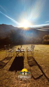 two chairs and a table in front of the sun at Foothill Pushkar Resort in Pushkar