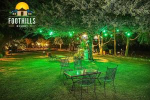 a group of tables and chairs in a park at night at Foothill Pushkar Resort in Pushkar