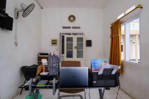 um quarto com uma secretária e um computador em RedDoorz at Putri Syariah Brebes 