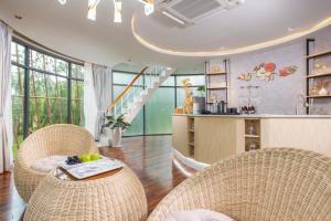 sala de estar con 2 sillas de mimbre y mesa en Bird Nest Villas by Mafiya en Sihanoukville