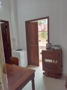 Zimmer mit Holztür, Tisch und Fenster in der Unterkunft Moon house tropical garden - Coconut in Nha Trang