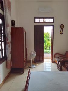 ein Wohnzimmer mit einem Tisch und einer Tür mit einem Ventilator in der Unterkunft Moon house tropical garden - Coconut in Nha Trang