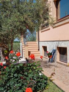 una casa con fiori rossi di fronte a una scala di Il Poggetto Marzamemi B&B a Marzamemi