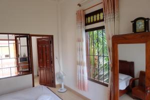 Schlafzimmer mit einem Bett, einem Fenster und einem Spiegel in der Unterkunft Moon house tropical garden - Coconut in Nha Trang