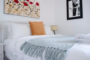 a white bed with a blanket on top of it at Mary Lemon Cottage - Heritage Home in Orange