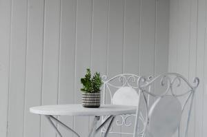 a white table and two chairs with a potted plant at Mary Lemon Cottage - Heritage Home in Orange