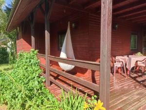 a porch of a wooden house with a table and chairs at Domek Zofiówka dostęp na kod in Zofiówka
